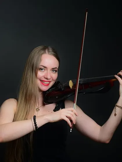 A smiling portrait of the violinist. This shot captures the joy that music brings her, creating a very positive and engaging image for her audience.