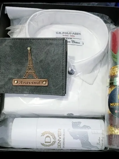 A perfect Valentine's gift hamper with a personalized wallet, a white shirt, deodorant, and a tube of Ferrero Rocher chocolates with a rose.