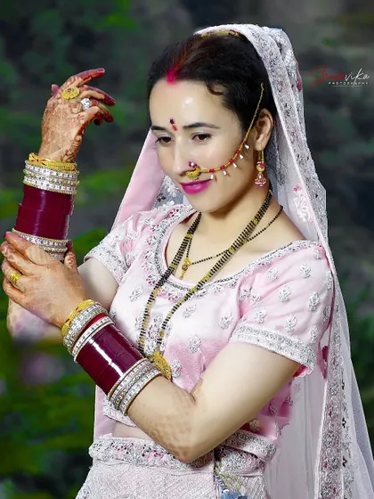 A lovely portrait of a bride in a simpler, post-wedding look, showcasing her bridal chooda (bangles) and mangalsutra.