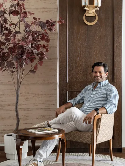 A photo of me, Shahen Mistry, in the Kutar's Residence. I'm sitting in a corner that perfectly reflects our design philosophy: blending heritage pieces with modern comforts to create a home that feels authentic and lived-in.