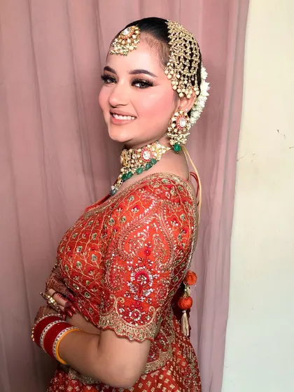 A side view of Bhoomi, showing her beautiful smile and the intricate details of her hair and jewelry.