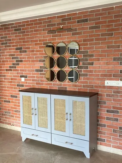 We paired an exposed brick wall with this custom-made cabinet featuring cane-paneled doors. The mix of rustic brick and refined woodwork creates a balanced, industrial-chic look.