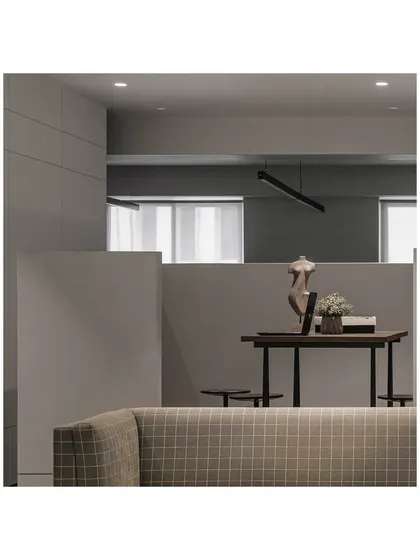 A view of the semi-open central meeting area, demarcated by a low partition. This design maintains an open feel while creating a functional space for client meetings or private work.