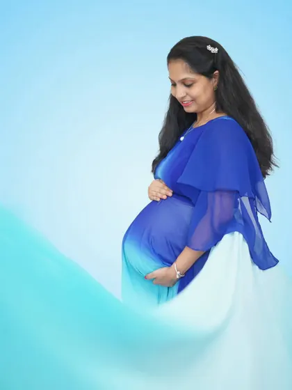 The ombre effect on this blue and white gown is just beautiful. It gives the feeling of a gentle wave, perfect for creating a serene and graceful maternity portrait.
