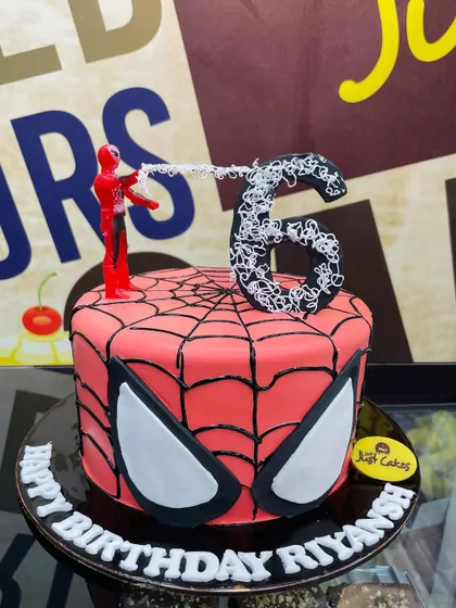 A 2.5kg Spider-Man mask cake with a web-shooting figurine for a 6th birthday.