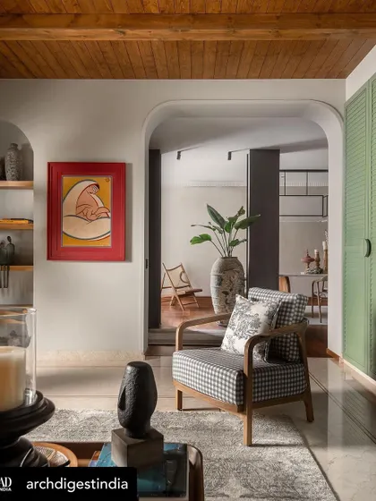 Another shot of the living room, framed by an archway. The composition emphasizes the layers of design, from the flooring to the furniture, art, and architectural details.