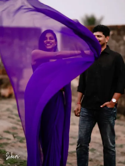 A candid moment of joy. The vibrant purple of her saree stands out, creating a beautiful and memorable image for this couple's pre-wedding album.