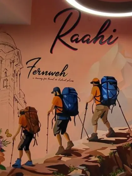 This mural was created for 'Raahi', a space that celebrates the spirit of travel. The artwork features hikers, a nod to the name 'Raahi' (traveler), and the word 'Fernweh', a German term for the ache to explore distant places.
