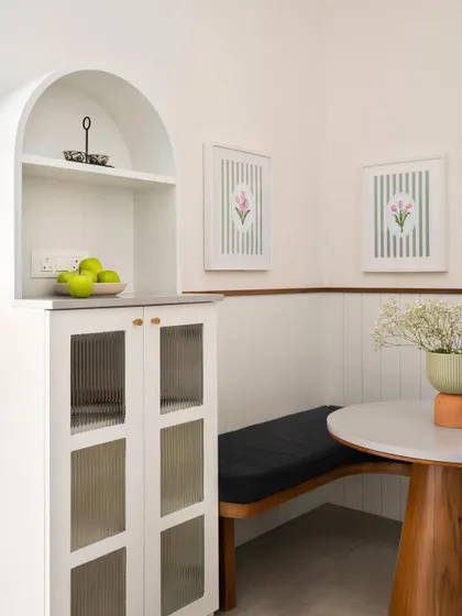 This cozy breakfast nook in the 'Palaash' project features a built-in bench and a charming arched curio cabinet. It’s a perfect example of how we create small, functional, and beautiful spaces for everyday life.