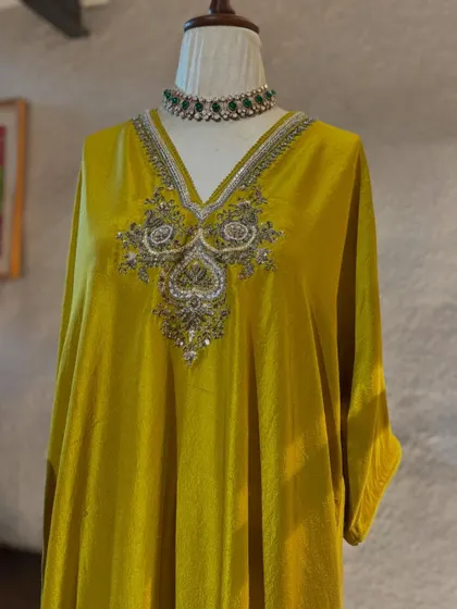 A stunning lime-green velvet kaftan by Jayanti Reddy. The intricate silver embroidery on the yoke is a testament to the designer's masterful craftsmanship.