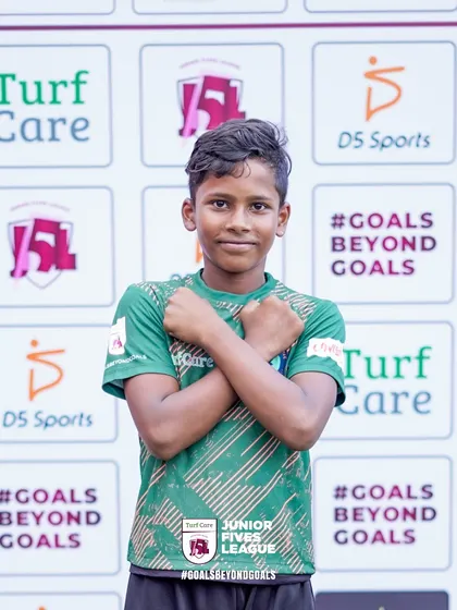 A young player poses with confidence in front of the official event backdrop. I create a media-rich environment where every child feels like a star.