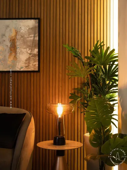 This simple and elegant table lamp features a warm filament bulb within a smoked glass shade. It's a perfect companion for a side table, providing a cozy and inviting ambient light for any corner.