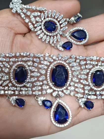 This is a grand American Diamond choker set with large blue stones. The design is bold and majestic, perfect for when you want to make a statement. It comes with matching drop earrings.
