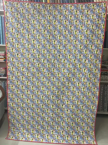 The fun, cartoon-themed backing fabric for the scrappy quilt.