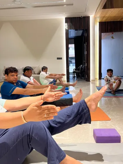 Focusing on core strength with Navasana (Boat Pose) during a corporate class. I use props like yoga blocks to help make poses more accessible for beginners.