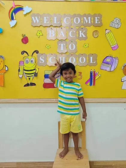 A duplicate of a previous image, showing a student in front of the 'Welcome Back' board.