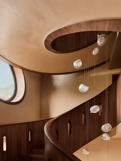 Another perspective of the cascading glass pendant lights along the spiral staircase. This angle highlights the fixture's organic, fluid form and how it interacts with the architecture of the space.