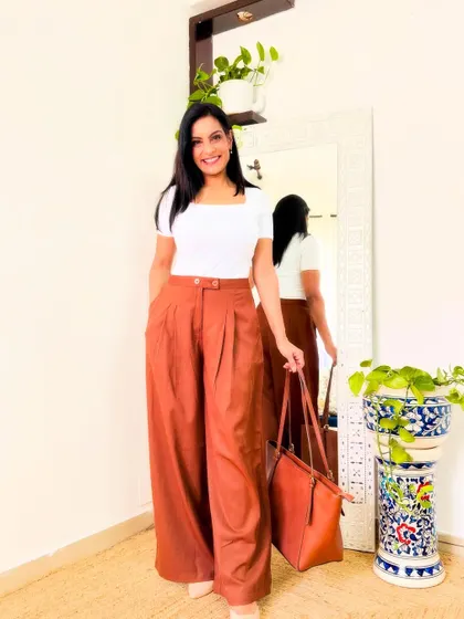 These rust-colored pleated trousers are a very trendy and stylish option. They add a pop of color to your workwear and look very chic.