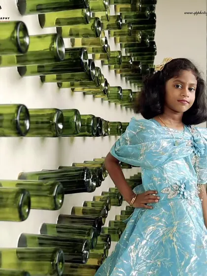 We can turn any location into a unique backdrop. Here, a wall of green bottles provides a modern and interesting setting for this young girl's stylish portrait.
