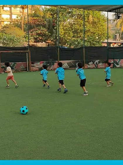 Look at them go! Our little athletes are running across the field during a warm up game. We start every session with activities that get their energy up and ready for a fun day of football.