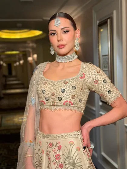 A Parisian beauty looking resplendent in Indian couture. The makeup is sculpted and luminous, with a clean, sharp finish that gives a high-fashion, almost editorial feel to her bridal look.