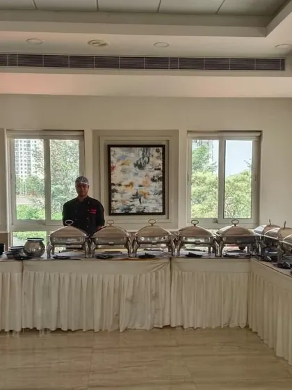 A sophisticated buffet setup with white linens for a house party at DLF Westend Heights.