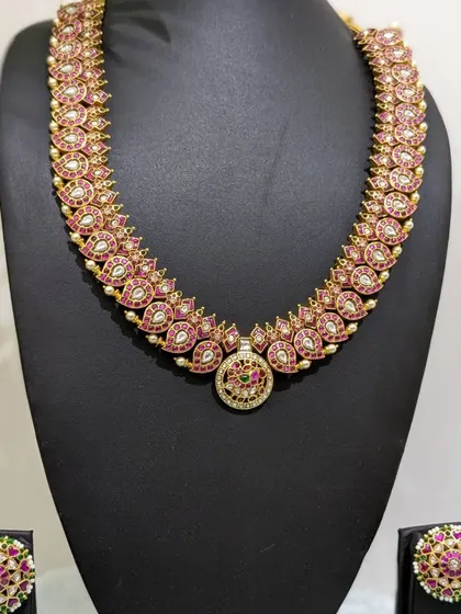This is a mid-size uncut real Jadau haara with ruby-colored stones and micro pearl studs. It's a simple yet stunning choice that can be styled in many ways.