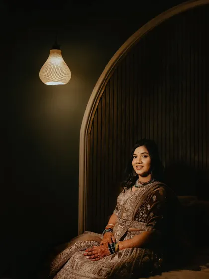 A quiet, elegant portrait of the bride, beautifully lit by a single pendant lamp, creating a moment of calm during the reception.