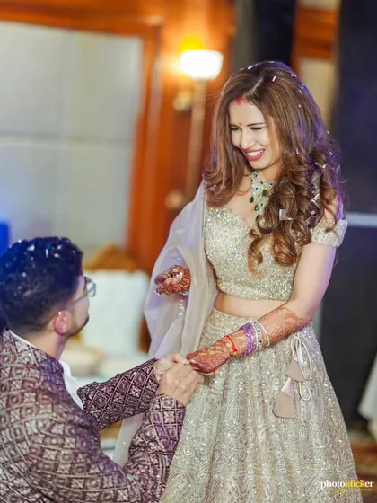 The groom-to-be gets down on one knee, a classic and timeless proposal moment captured during their engagement ceremony.