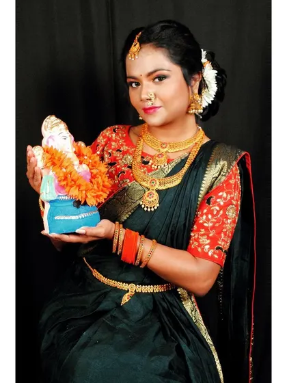 A beautiful portrait of the model in her Maharashtrian attire, holding a Ganesha idol. The makeup is flawless and captures the festive mood.