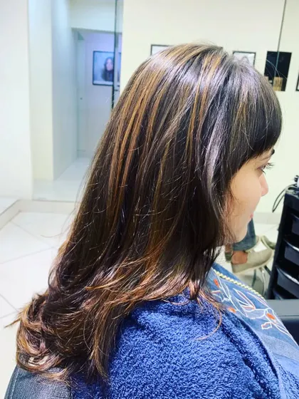 Beautiful highlights can completely refresh your look. Here, we added warm, honey-toned strands to brighten up the client's natural brunette hair.