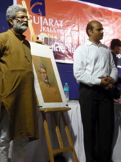 Standing beside my completed portrait of Shri Vasudevji Kamath at an event by Gujarat Kala Pratishthan. It is a moment of pride to present the artwork next to the person who inspired it.