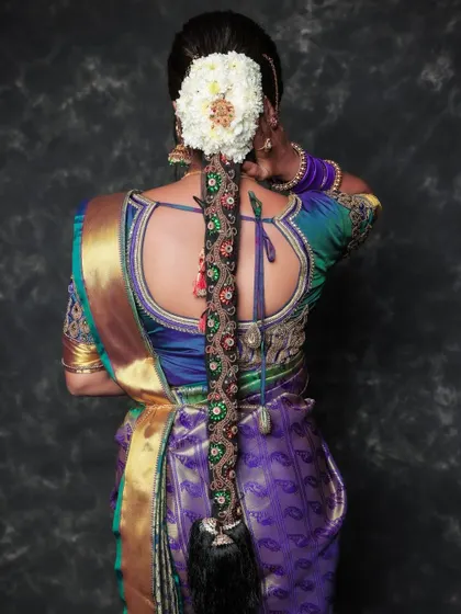 A back-profile shot focusing on the bride's elaborate hairstyle. The beautifully embroidered blouse and the traditional hairpiece are the stars of this detailed portrait.