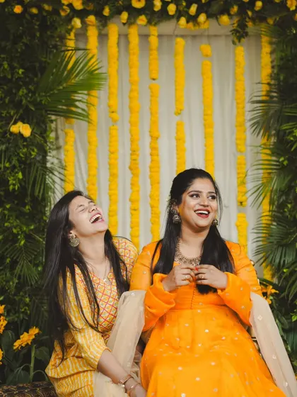 Laughter and friendship at a Haldi ceremony. We created a photo-friendly backdrop with marigold strings and lush green palms for guests to take pictures.