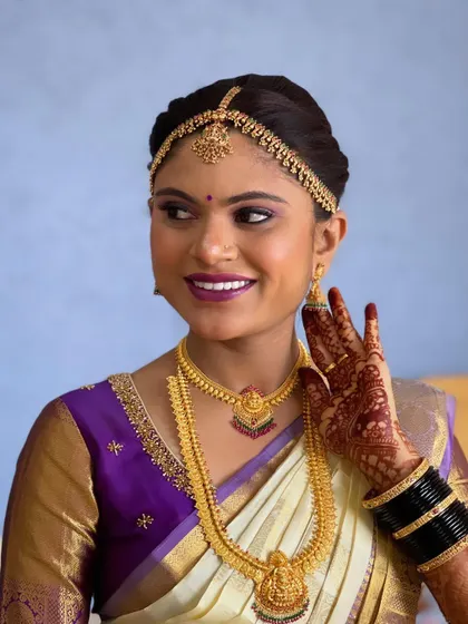 A happy, candid moment. The bride's makeup looks fresh and vibrant, highlighting her joyful expression.