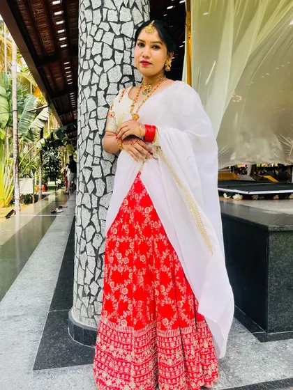 A client looking graceful in a traditional red and white half saree.