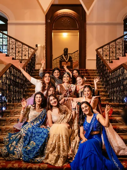 A fun and candid moment with the bride and her bridesmaids on the grand staircase.