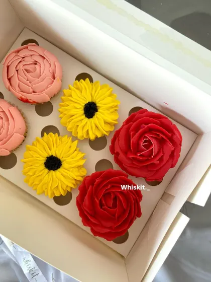 A top-down view of the handcrafted floral cupcakes, highlighting the different flower designs and bright colors in one beautiful assortment.