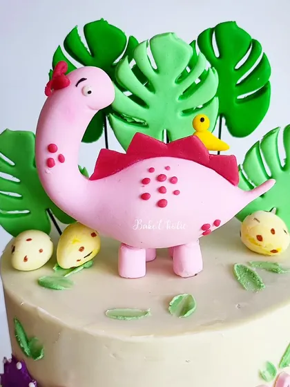 A close-up of the pink dinosaur topper. All these accents are handcrafted from fondant and completely edible.