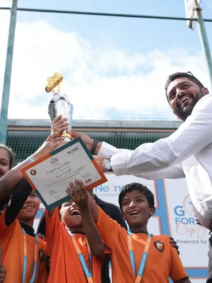 Victory! Our technical director, Adhip Bhandary, presents the championship trophy to a winning team at the Goal for the Good Cup. We love celebrating success and sportsmanship.