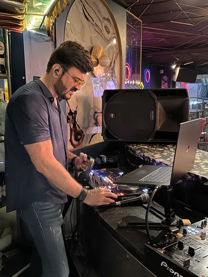 Focused on the mix at a bustling club. This is my zone, where I blend tracks to keep the party going strong.