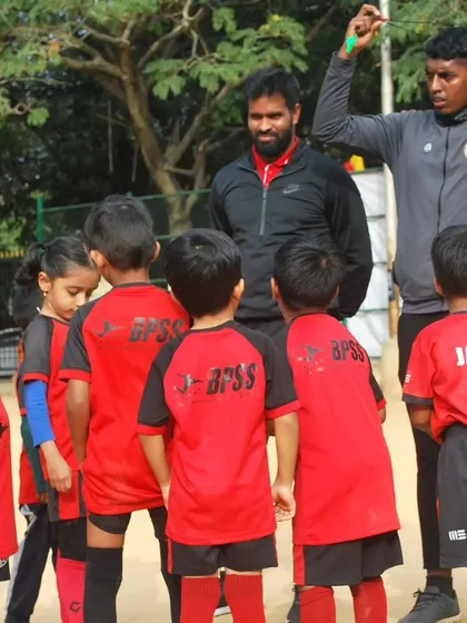 My coaches and I gather our youngest players for a quick team talk. I make sure to create a supportive environment where even the smallest players feel heard, valued, and excited to learn.