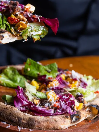 Can't decide between a pizza and a salad? I've created the perfect solution. This is my pizza salad, a fresh and vibrant mix of greens and toppings served on a warm, seasoned pizza crust. It's the best of both worlds.