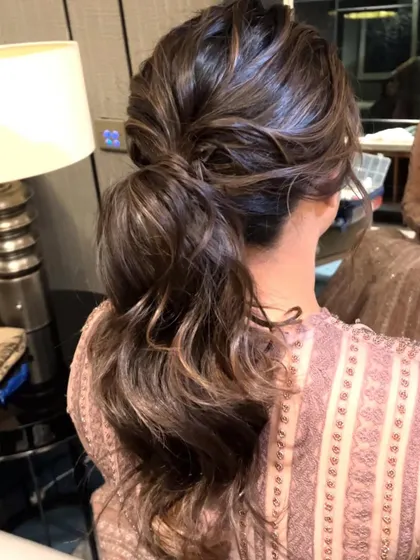 A close-up of the messy low ponytail, a perfect example of relaxed glamour.