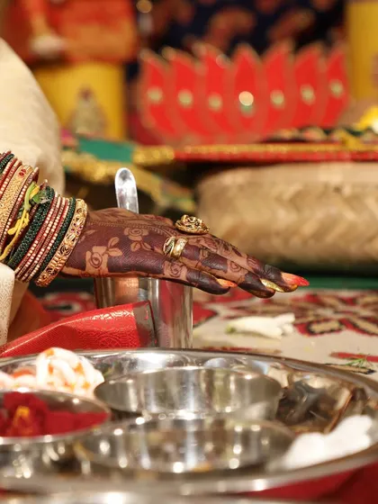 An artistic close-up of the bride's hand during a wedding ritual, highlighting the rich color of the henna.