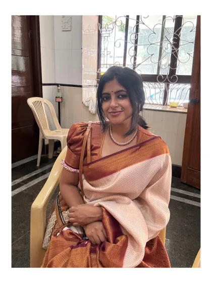 A quiet, seated moment in a traditional saree.
