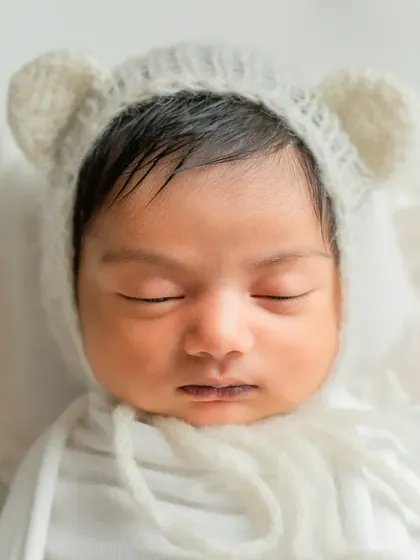 An intimate, tight close-up of the baby's face, emphasizing their perfect, sleepy innocence.