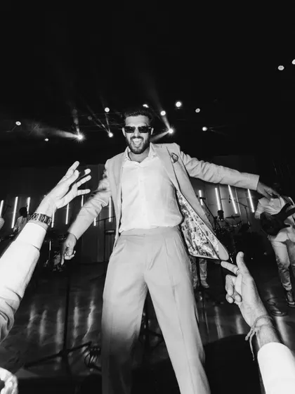 A high-energy, low-angle shot of the groom, Jaymit, on the dance floor. This black and white photo captures the fun and excitement of the reception.