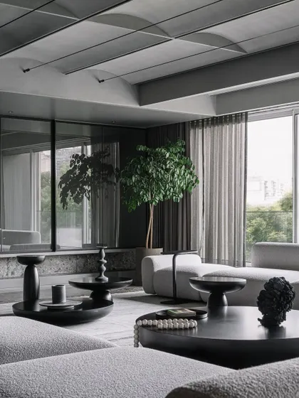 The material palette of the Vaulted Haus living area is rendered in a refined grey scale. To add depth and interest, we incorporated abundant plant greens, which bring a vibrant and lively touch to the monochromatic interiors.