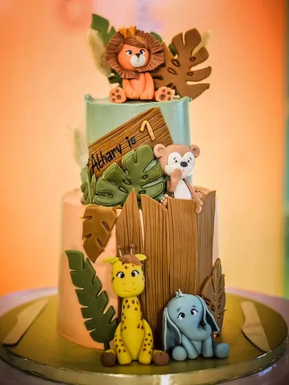 Atharv's wild and free first birthday party cake. This two-tier chocolate truffle cake has a rustic, woodland feel with hand-sculpted animals and wooden textures.